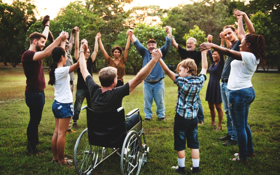 Menschen stehen im Kreis und halten sich an den Händen